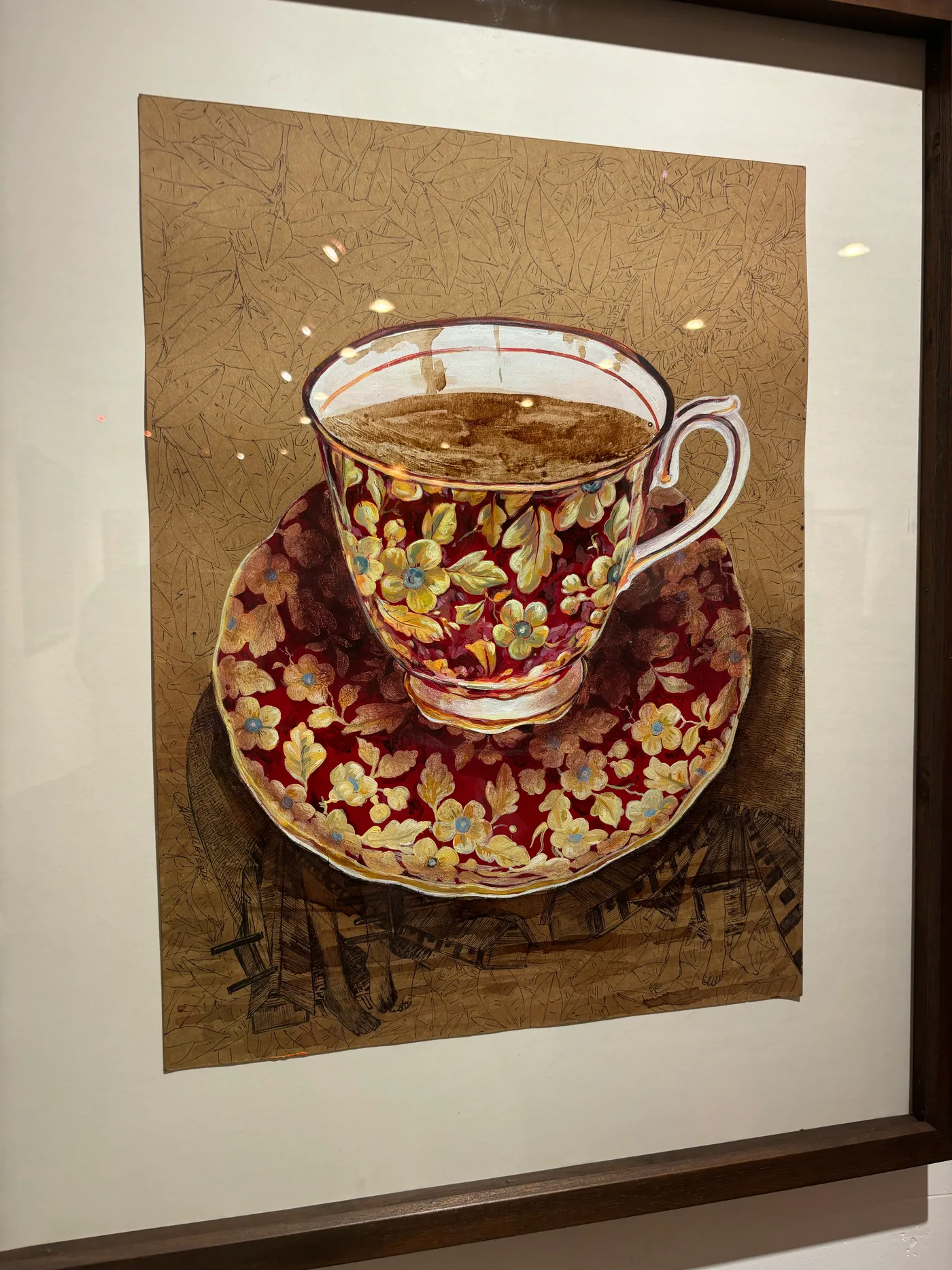 A framed painting of an ornate teacup on tea-stained paper.