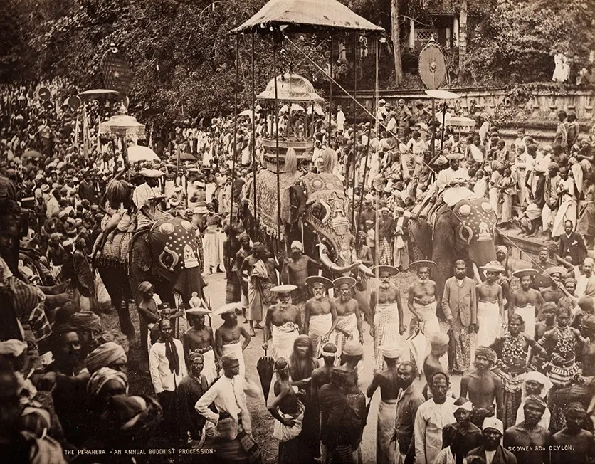 Albumen print by Scowen & Co, c.1880, showing an annual Buddhist procession moving through a street in Ceylon.