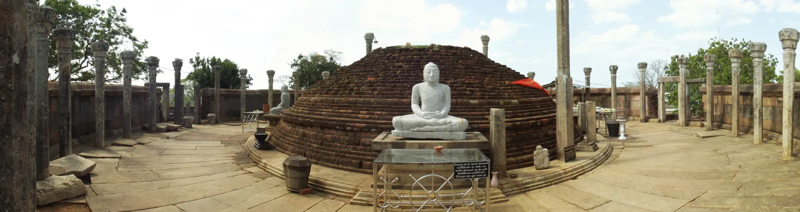 The Tiriyaya (Girihandu Seya) vatadage on a hilltop near Trincomalee, a circular platform with a central brick stupa, a seated Buddha, and a ring of stone pillars.