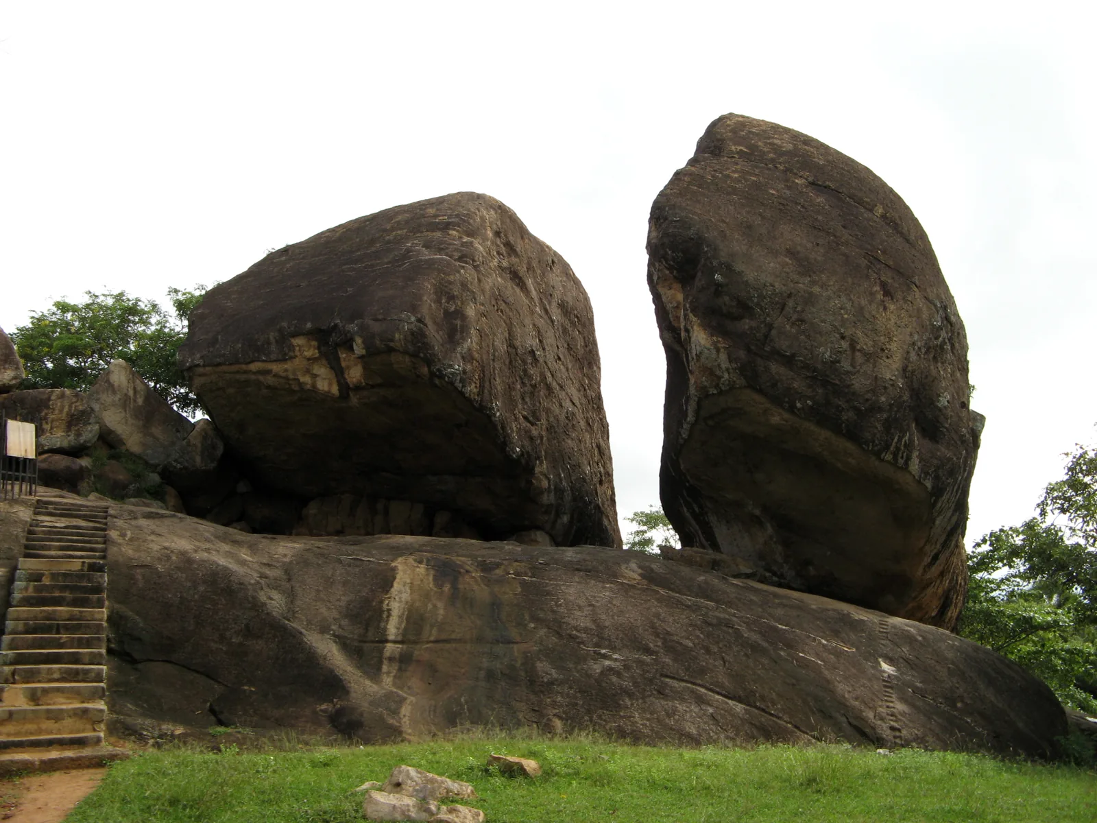 The great granite boulders and rock shelters of Vessagiriya near Anuradhapura, with steps cut at their base.