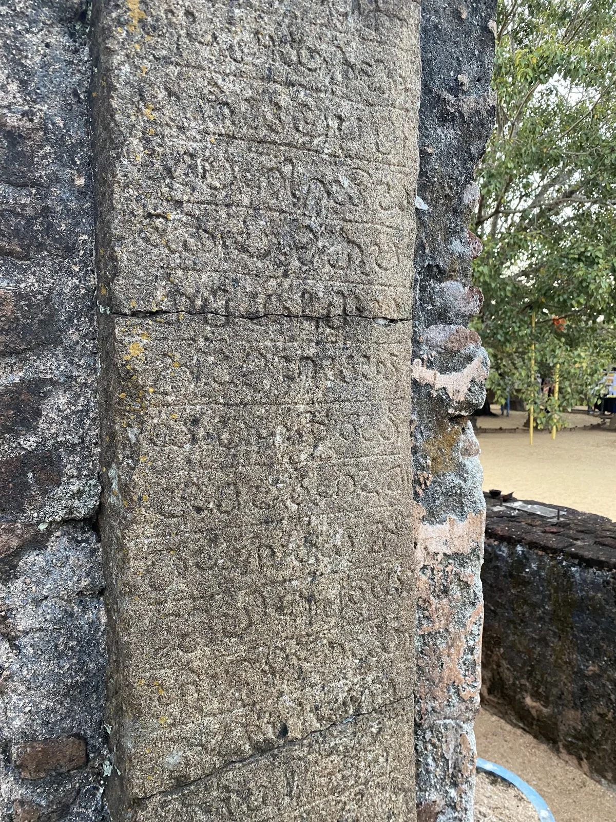 A carved Sinhala inscription at Polonnaruwa, rows of rounded twelfth-century letters cut on a stone band.