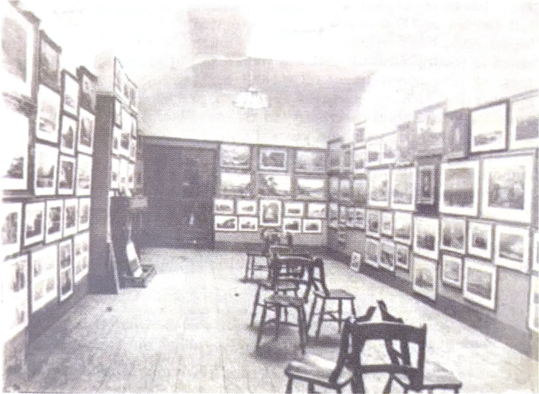 A contemporary photograph of a gallery hung floor to ceiling with framed watercolours.