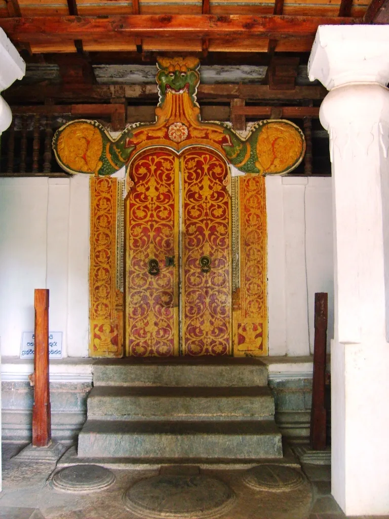 The painted entrance doorway of Degaldoruwa temple near Kandy, worked in red and gold floral ornament.