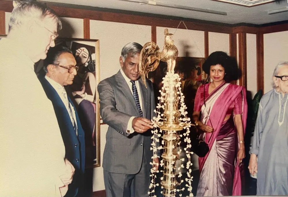 A guest lighting a brass oil lamp at a George Keyt exhibition opening.