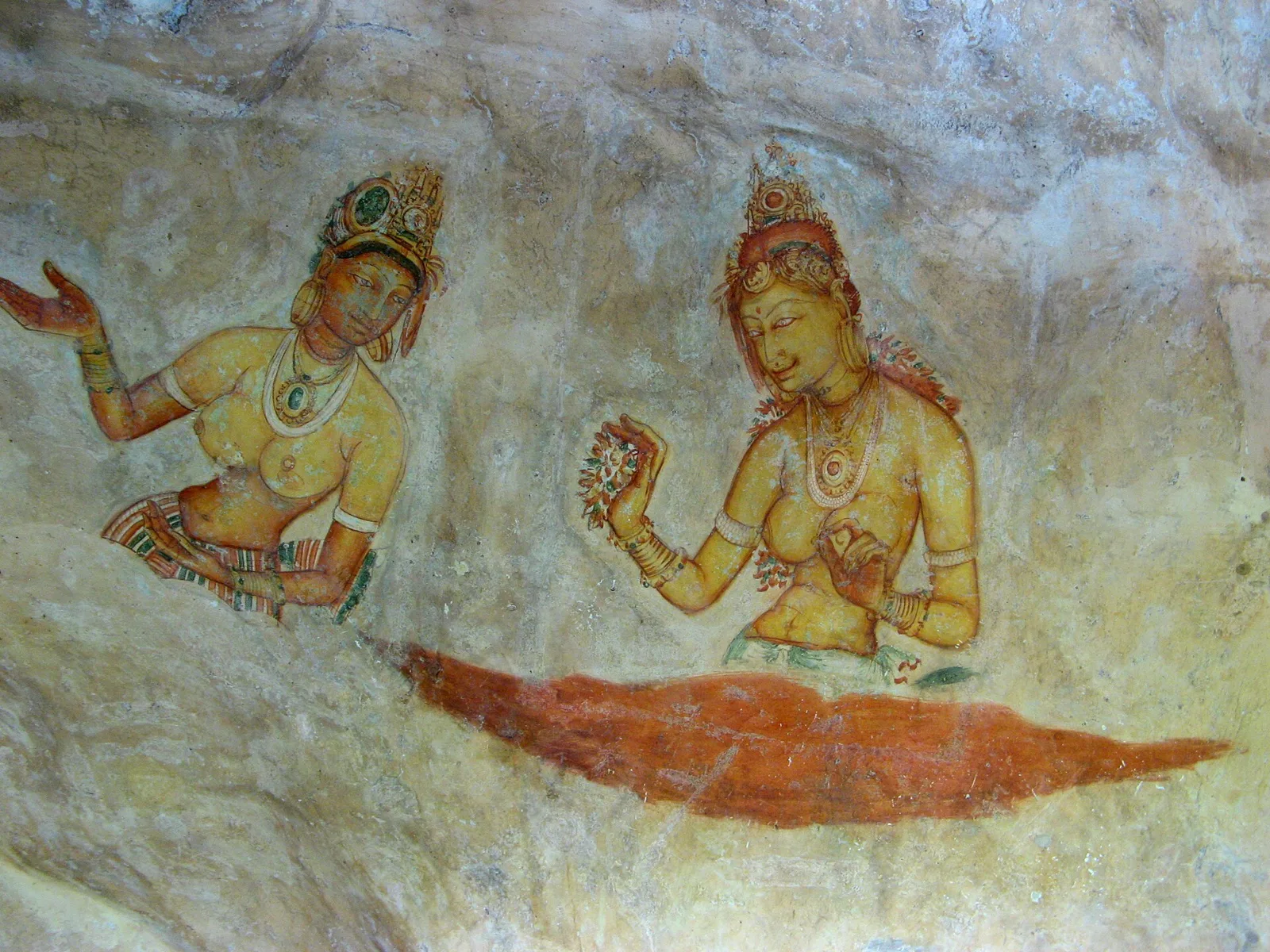 Two of the celestial women of Sigiriya, among the best preserved of the surviving figures, one holding a spray of flowers, both bejewelled and rising from cloud.